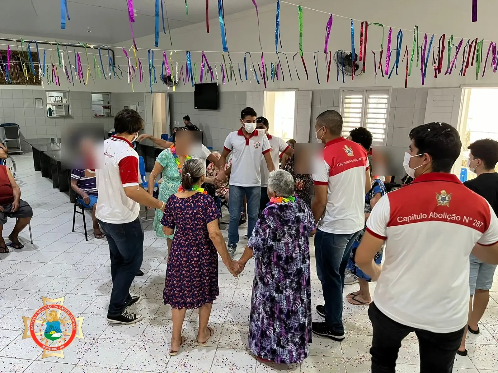 Jovens do Capítulo dançam de mãos dadas com idosas em uma ação social de carnaval