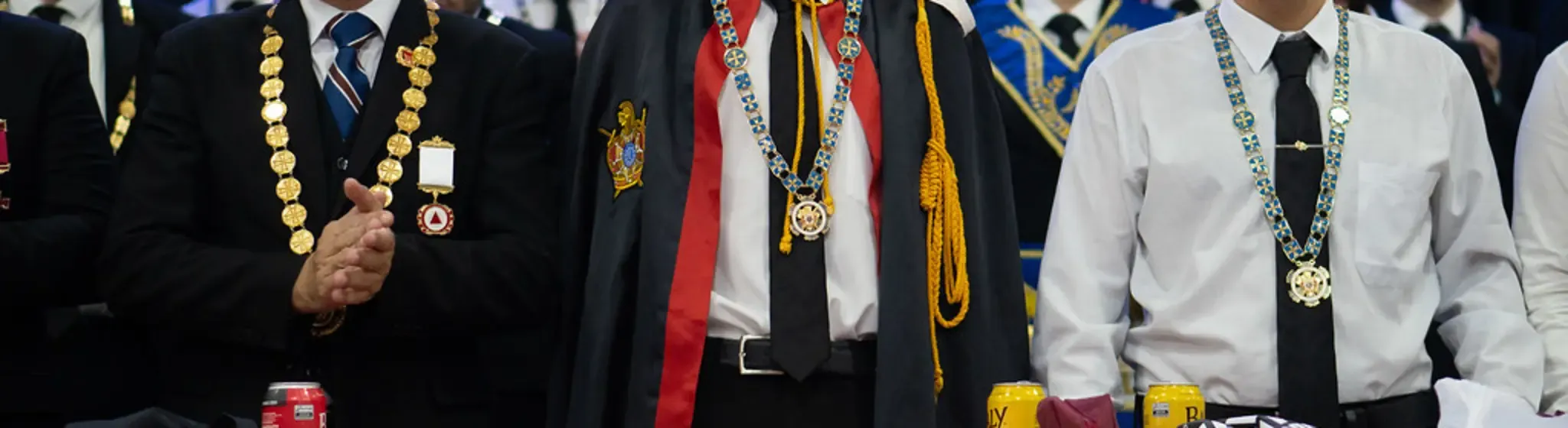 Detalhe das capas e colares cerimoniais de DeMolays lado a lado em um evento da Ordem