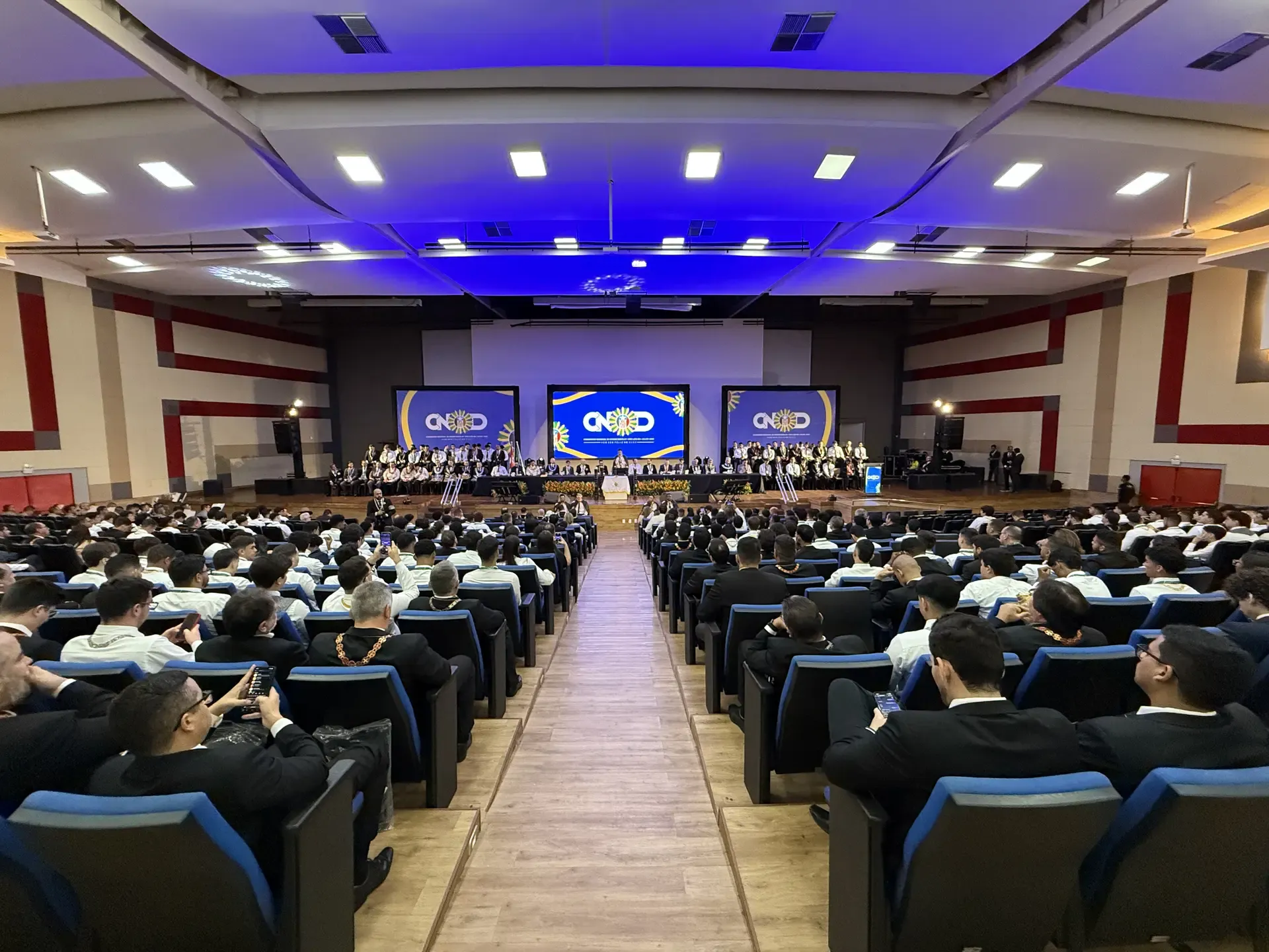 Plateia lotada de DeMolays de terno no auditório do Congresso Nacional da Ordem DeMolay