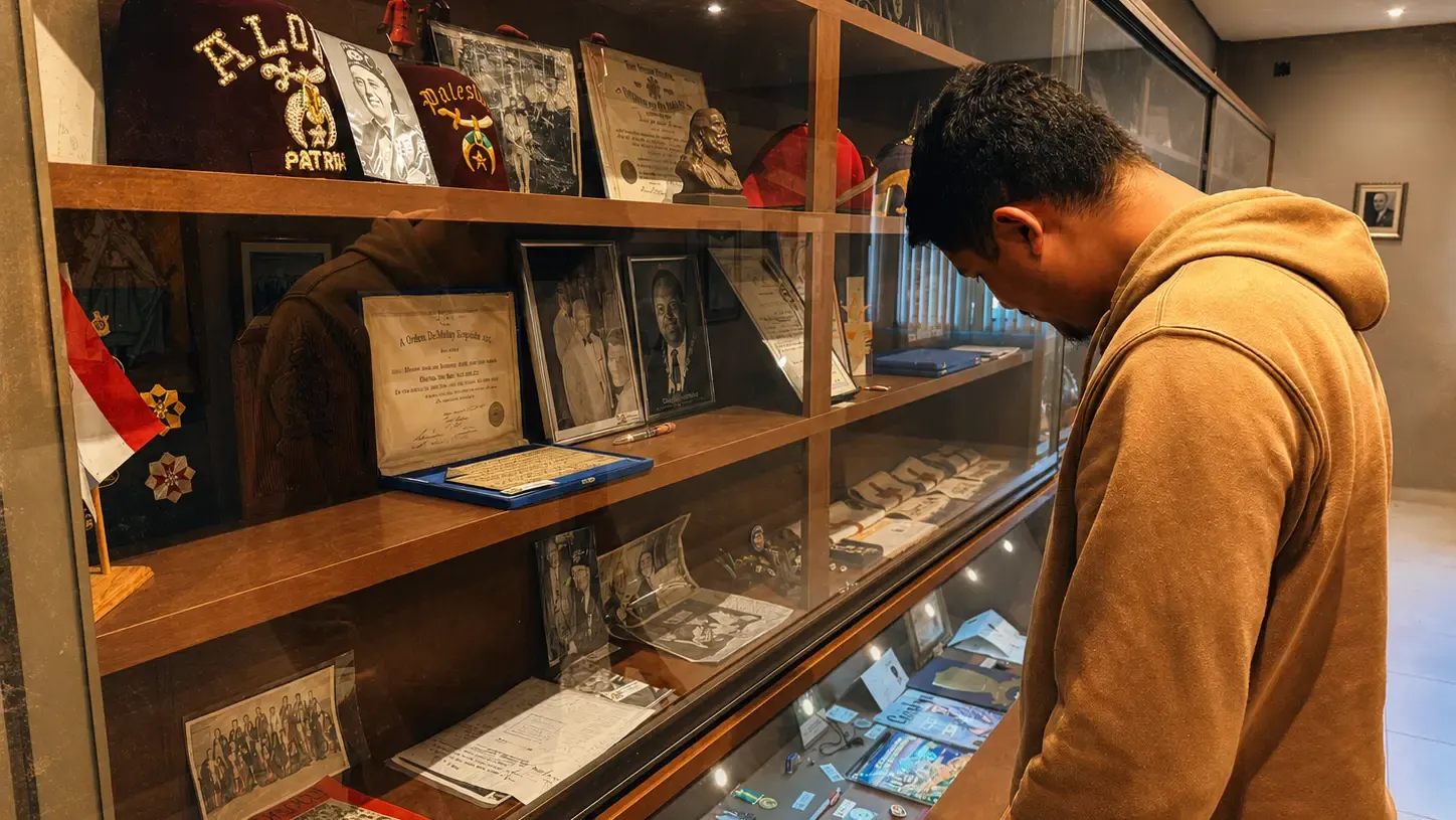 Visitante observa uma vitrine do Memorial DeMolay com documentos, fotografias e peças históricas da Ordem
